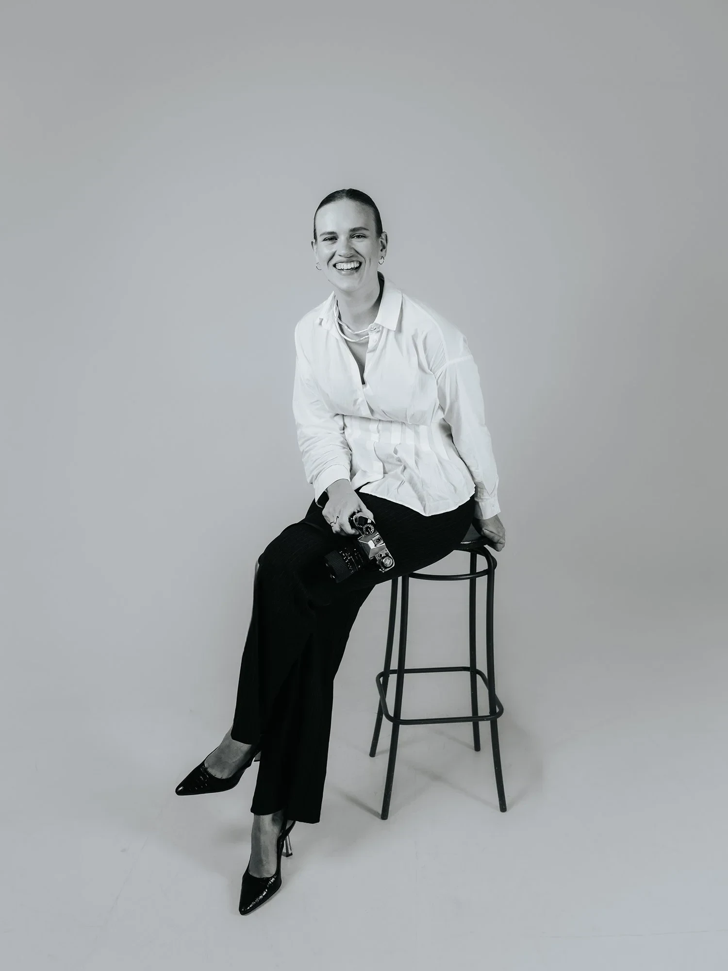 Portrait of a woman sitting on a stool