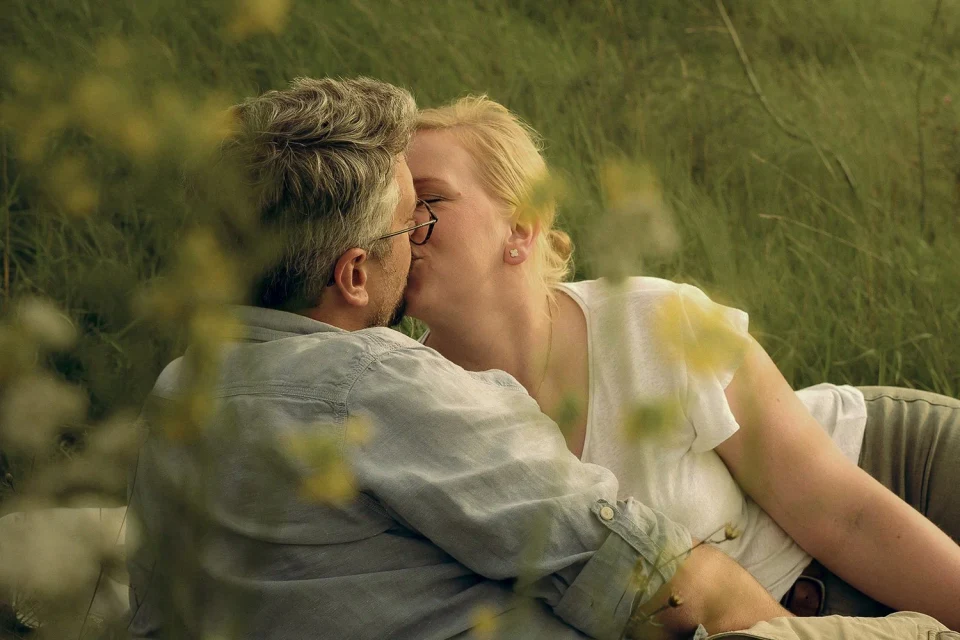Couple lying in a meadow and kissing