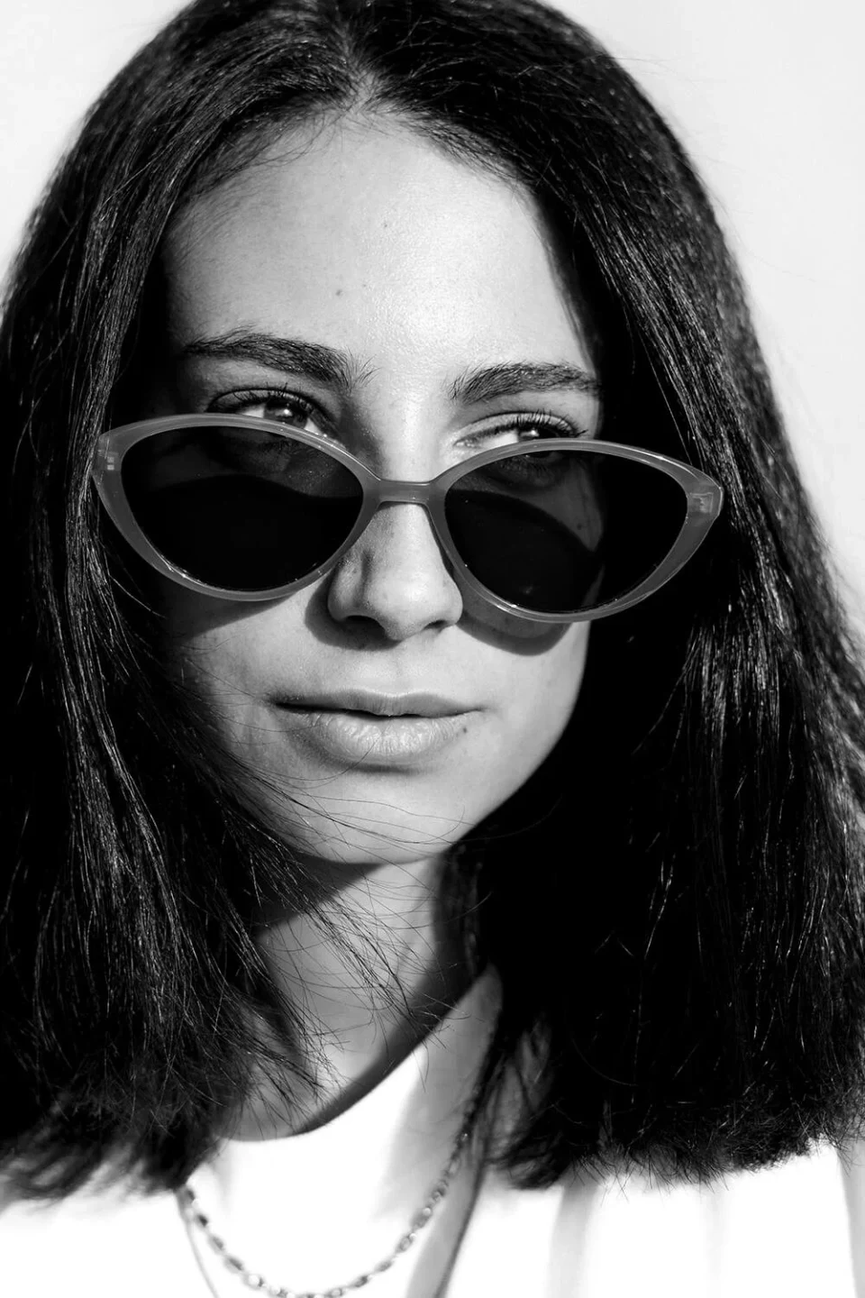 Close-up portrait of a dark-haired woman wearing sunglasses