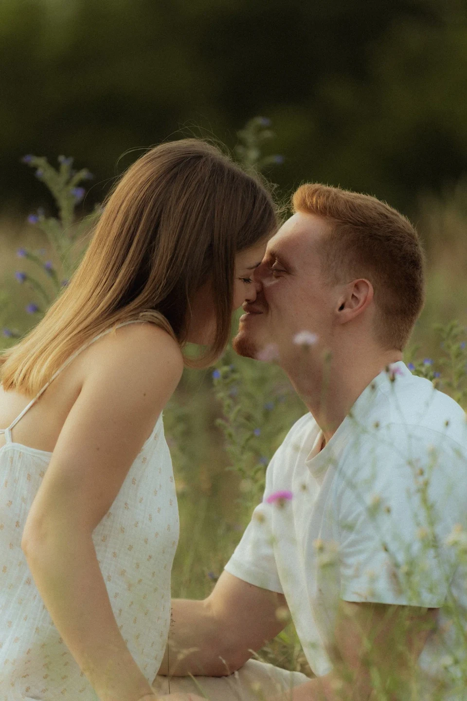 Couple sharing a kiss in a meadow
