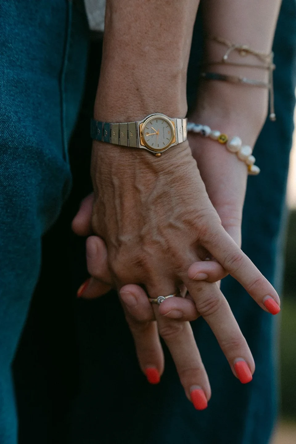 Close-up of two hands with jewellery and red nails