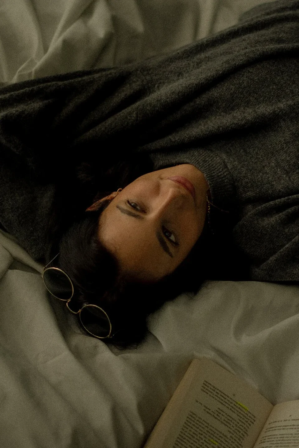 Woman lying on a white blanket and looking up