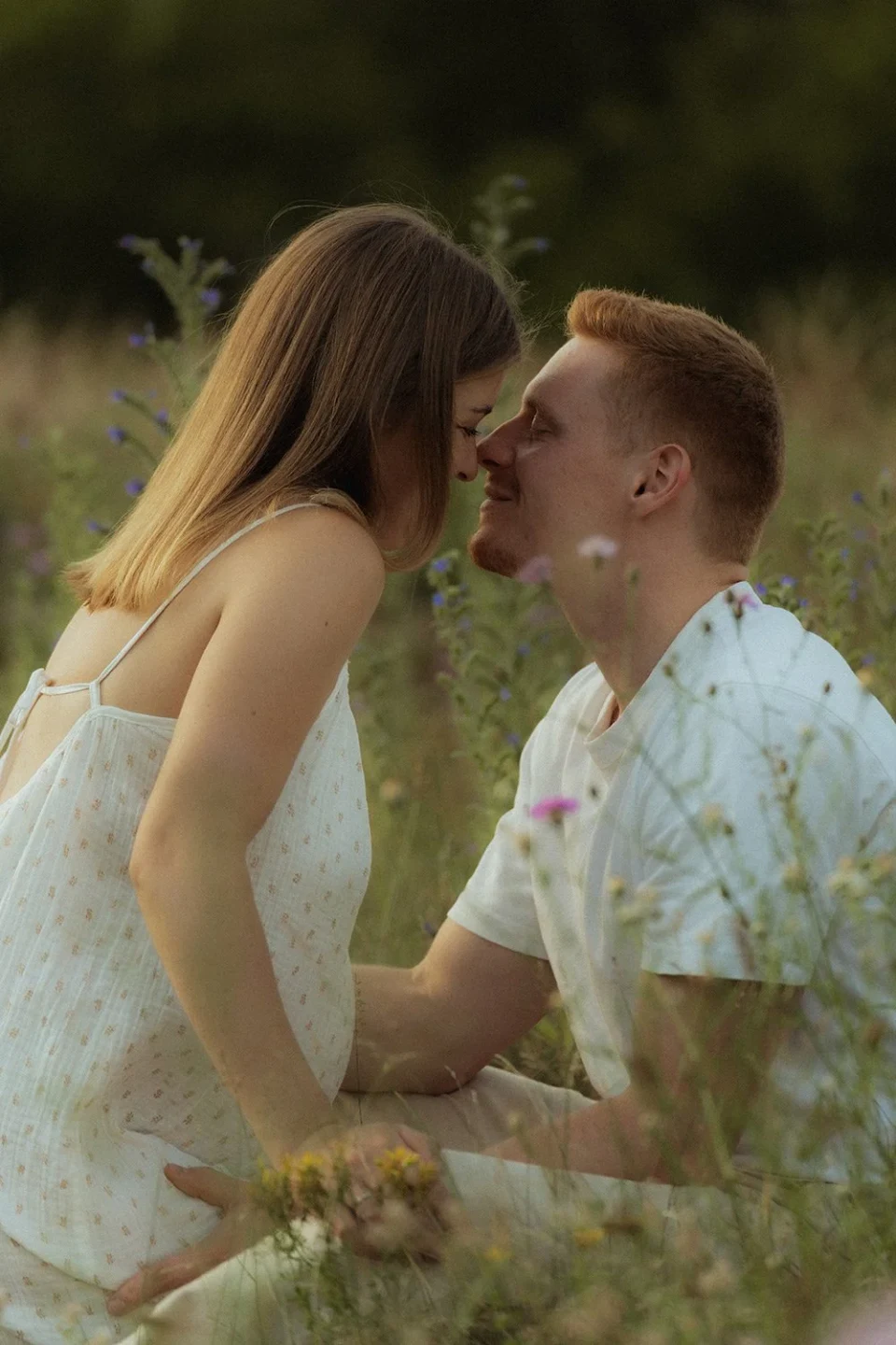 Couple sitting close together in a meadow