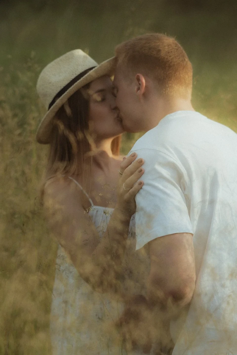 Couple standing in a meadow and kissing
