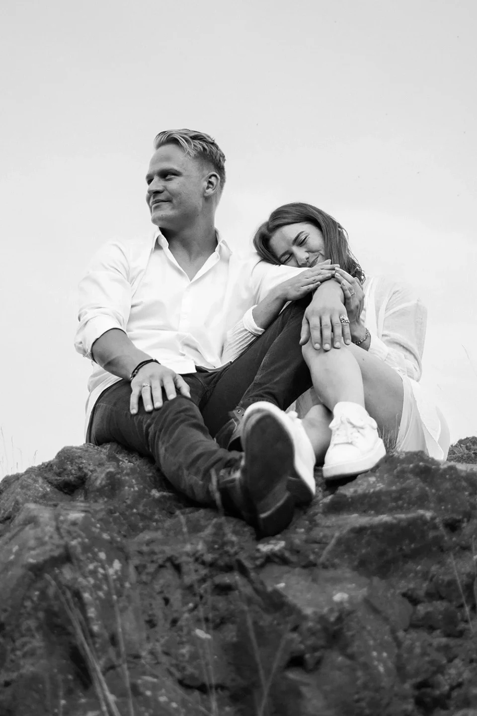Young couple leaning against each other on a rock