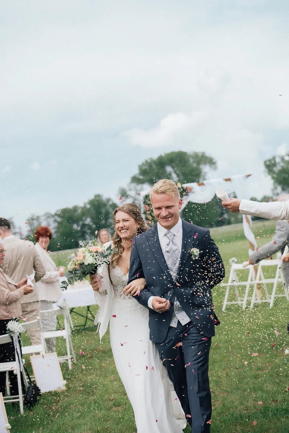 Couple leaving their ceremony under confetti